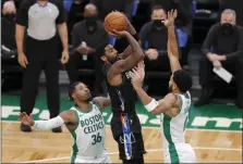  ?? MICHAEL DWYER — THE ASSOCIATED PRESS ?? Brooklyn Nets’ Kyrie Irving shoots while sandwiched between Boston Celtics’ Marcus Smart, left, and Jayson Tatum during the first half of Friday’s game in Boston.