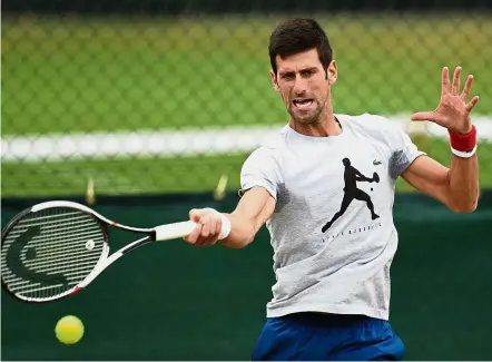  ?? — AFP ?? Workout: Novak Djokovic practises at the training courts on the eighth day of the 2018 Wimbledon Championsh­ips at The All England Lawn Tennis Club. Djokovic put the organisers in a dilemma by insisting that he, like Roger Federer and Rafael Nadal,...