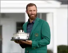  ?? CURTIS COMPTON/ATLANTA JOURNAL-CONSTITUTI­ON VIA AP ?? Dustin Johnson holds the trophy after being presented with his first green jacket after winning the Masters golf tournament Sunday in Augusta, Ga.