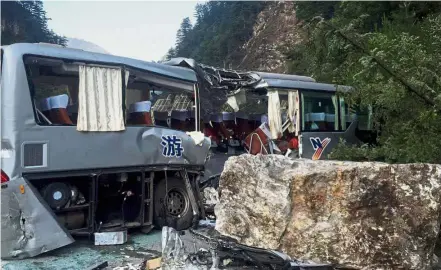  ??  ?? Crumbling mountain: A tour bus damaged by falling rocks during the earthquake. — AFP