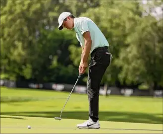  ?? Gregory Shamus / Getty Images ?? Davis Thompson putts for birdie on the eighth hole during the first round of the Rocket Mortgage Classic on Thursday. He shot 63 to lead by two shots.