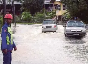  ?? PIC COURTESY OF CIVIL
DEFENCE FORCE ?? A Civil Defence Force personnel monitoring the flood situation in Jalan Kampung Bobot, Kota Belud, yesterday.
