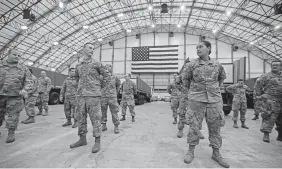  ??  ?? The National Guard stands by to help offload the New England Patriots plane after returning from Shenzhen, China with 1.2 million N95 masks.