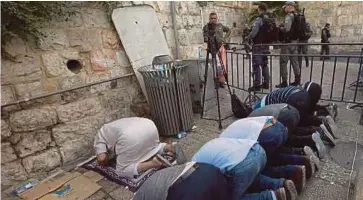 ??  ?? SEKUMPULAN lelaki menunaikan solat di sebelah Pintu Singa selepas
enggan melalui peralatan keselamata­n yang diletakkan di laluan masuk ke pekarangan
Masjid Al-Aqsa. - EPA