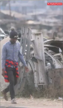  ??  ?? Pic: Shepherd Tozvireva
A man walks passes by a heap of scrap metal along Cripps Road in Granitesid­e, Harare, yesterday