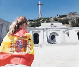  ??  ?? ► Una mujer envuelta en una bandera en el Valle de los Caídos.