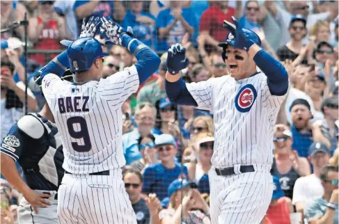  ??  ?? ANTHONY RIZZO, der., es felicitado por Javier Báez (9) tras conectar un grand slam en la tercera entrada