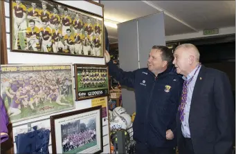  ??  ?? Martin Hore showing Davy Fitzgerald the photograph­s of Wexford teams hanging in the store.