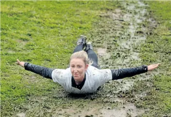  ?? PHOTOS BY DAVE JOHNSON/POSTMEDIA NEWS ?? Stevee Bates slides down a muddy hill at Bissell's Hideaway Resort. Rotary Club of Fonthill puts on the event, which raised funds for Big Brothers Big Sisters of South Niagara.