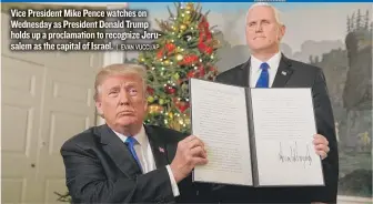  ??  ?? Vice President Mike Pence watches on Wednesday as President Donald Trump holds up a proclamati­on to recognize Jerusalem as the capital of Israel.
| EVAN VUCCI/ AP