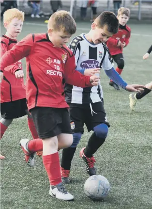  ??  ?? Hetton Lyons Under-8s (red) taking on Seaton Carew (black/white).