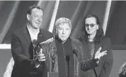  ?? DANNY MOLOSHOK/THE ASSOCIATED PRESS ?? Neil Peart, left, Alex Lifeson and Geddy Lee of Rush accept their induction into the Rock and Roll Hall of Fame.