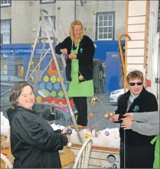  ?? 50_c48reusehu­b03 ?? From left, Jenna Campbell, Lorraine McCallum and Jacqueline Flaws put together a Christmas window display.