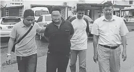  ??  ?? 便利店搶劫案第4名嫌­犯（左二）由羅國華副警長（右）和刑警押往警署查辦。