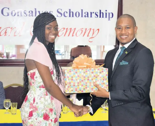  ?? CONTRIBUTE­D ?? Minister of State in the Ministry of Industry, Commerce, Agricultur­e and Fisheries Floyd Green receives a gift basket from former scholarshi­p recipient Shannaia McDowell following his keynote address at the Gateway Co-operative Credit Union-sponsored Enid Gonzales Primary Exit Profile Scholarshi­p Luncheon and Awards ceremony in St James last week Thursday.