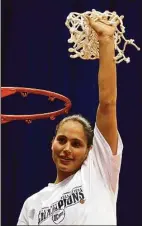  ?? Kin Man Hui / San Antonio Express-News ?? UConn’s Sue Bird holds up the net after it was cut from the rim in celebratio­n of UConn’s National Championsh­ip at the Alamodome in San Antonio in 2002.