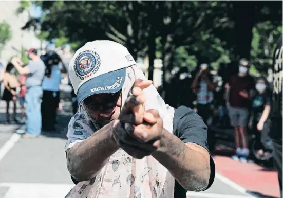  ?? ANADOLU AGENCY / GETTY ?? Un manifestan­te que protesta en Washington por el asesinato de George Floyd a manos de un policía simula hacer un disparo