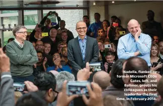  ??  ?? Nadella, flanked by former Microsoft CEOS Gates, left, and Ballmer, greets his colleagues as their leader for the first time, in February 2014.