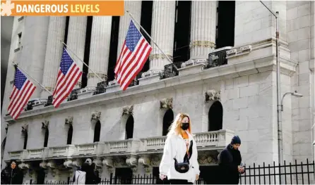  ?? — Reuters ?? A woman wears a mask near the New York Stock Exchange (NYSE) in the Financial District in New York.