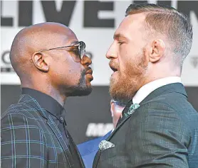  ??  ?? Mayweather (E) e McGregor na tradiciona­l encarada antes do combate