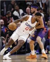  ?? CHRIS CODUTO/GETTY IMAGES ?? Paul George drives on Devin Booker of the Suns during the Clippers’ victory Wednesday night in Phoenix.