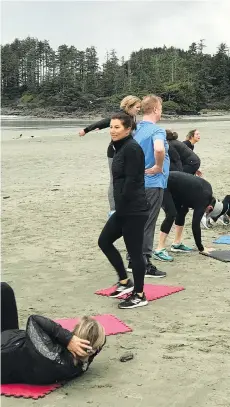  ??  ?? Trainer Michele Shorter, centre, leads participan­ts through standard exercises like crunches on the sand at the Beauty and the Beach Bootcamp.