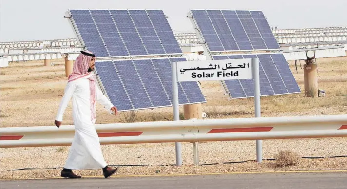  ??  ?? ► Un saudita camina al lado de una granja de paneles solares en el centro de estudios Al-Oyeynah.