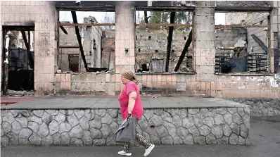  ?? AP Photo/Natacha Pisarenko ?? A woman heads to the market Tuesday in Makariv on the outskirts of Kyiv, Ukraine.