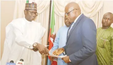  ??  ?? Gov. Mai
Mala Buni of
Yobe State (left) exchanges copies of agreements signed with the Managing Director of Family Homes Funds Ltd, Mr Femi Adewole for the constructi­on of 2600 housing units in Yobe State. The agreement was signed at the Yobe Governor’s Lodge in Asokoro, Abuja yesterday.