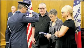  ?? The Sentinel-Record/Grace Brown ?? REUNITED: Staff Sgt. Thomas Briseño with the U.S. Air Force presents a folded flag to Joyce McGuiggan, center, and her two children, Jerry McGuiggan and Tami Fason, during a ceremony honoring her late son, Tech Sgt. Robert McGuiggan. The flag McGuiggan...