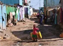  ?? SIMON MAINA/AFP/GETTY IMAGES ?? A boy carries water jugs in a slum area of Djibouti, a country where 42 per cent of the population lives in extreme poverty.