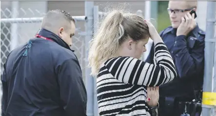  ?? IAN KUCERAK ?? Family members speak with police after violence broke out at a north Edmonton apartment complex on 144 Avenue on Thursday.