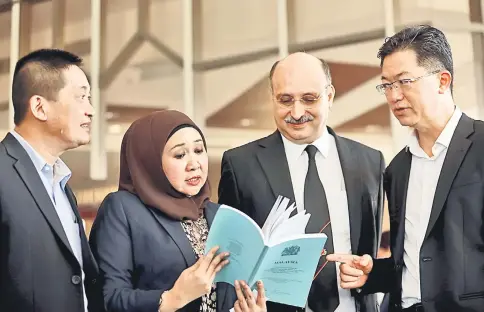  ??  ?? Sharifah Hasidah (second left) browsing a document with Ranbir Singh. Also seen are See (left) and Lau (right).