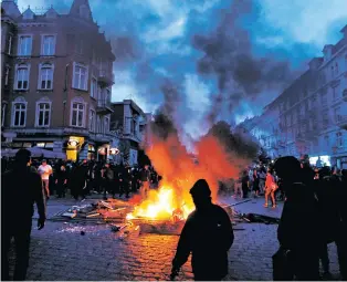 ?? MICHAEL PROBST/THE ASSOCIATED PRESS ?? Protesters stand around fires on a street Friday during a protest against the G-20 summit in Hamburg, Germany.