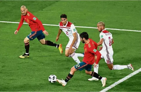  ?? — Reuters ?? Going all out: Spain’s Isco (second from right) passing the ball to David Silva (left) during the Group B match against Morocco at the Kaliningra­d Stadium on Monday.