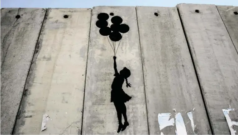  ?? BILD: SN/GETTY IMAGES ?? Der Graffiti-Künstler Banksy will auf der Mauer, die Israel von Palästina trennt, auf die Lebensumst­ände der Menschen dahinter aufmerksam machen.