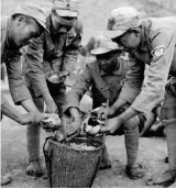  ??  ?? 抗日战争期间，国军的军粮以大米为主。图为士兵在盛米饭