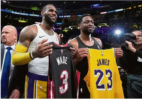  ?? — AFP ?? So long: LeBron James (left) of the Los Angeles Lakers and Dwyane Wade (right) of the Miami Heat pose for a photo after exchanging jerseys at the end of their NBA game on Monday. Wade plans to retire at the end of the season.