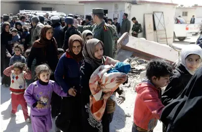  ?? AFP ?? Syrian civilians, evacuated from rebel-held areas in the Eastern Ghouta, queue at a school in the regime-controlled Hosh Nasri, on the northeaste­rn outskirts of the capital Damascus on Friday, as they board a bus to be relocated to other areas. —