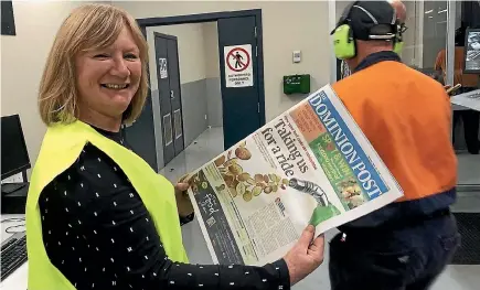  ?? SINEAD BOUCHER/STUFF ?? Bernadette Courtney, editor-in-chief of newsrooms, takes a look at the new Dominion Post compact coming off the press.