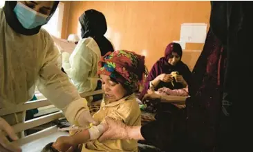  ?? KIANA HAYERI/THE NEW YORK TIMES 2022 ?? Nurses treat a measles patient March 6 in a hospital in Herat, Afghanista­n. Since the Taliban administra­tion banned women from aid work, many groups have suspended their operations in the country.