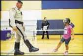  ??  ?? Metropolit­an Police Department traffic bureau officer Michael Lemley administer­s a mock field sobriety test to Jordan Rowe, 5, during the Citywide Traffic Safety Block Party.