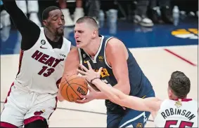  ?? DAVID ZALUBOWSKI/AP PHOTO ?? Nuggets center Nikola Jokic, center, tries to get past Miami Heat center Bam Adebayo (13) during the second half of Game 2 the NBA Finals on Sunday in Denver.