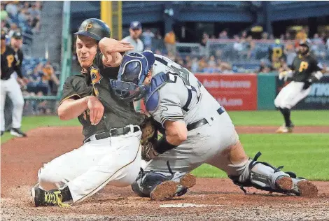  ?? ASSOCIATED PRESS ?? Brewers catcher Stephen Vogt suffers a strained neck and left knee in a collision at the plate with Pirates starting pitcher Chad Kuhl on Monday.