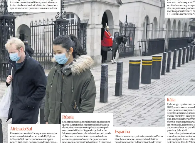  ??  ?? Duas pessoas de máscara passam no centro de Londres. A capital britânica encerrou estações de metro.