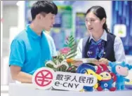  ?? PROVIDED TO CHINA DAILY ?? A bank employee introduces e-CNY to a visitor during an expo in Shanghai.