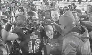  ?? Arkansas Democrat-gazette/rick MCFARLAND ?? Interim Arkansas State coach John Thompson (center) celebrates the Red Wolves’ victory in the GoDaddy.com Bowl on Sunday with Kyle Coleman (12) and others. Thompson now returns to his duties as defensive coordinato­r for new coach Bryan Harsin.