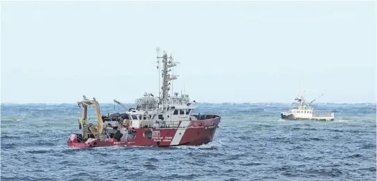  ?? TIM KROCHAK • THE CHRONICLE HERALD ?? The Canadian Coast Guard ship M. Perley passes a fishing boat while searching for crew members of the Chief William Saulis, which sank on Tuesday.