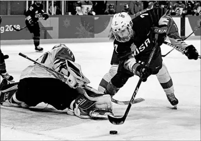  ?? CARLOS GONZALEZ/MINNEAPOLI­S STAR TRIBUNE ?? Monique Lamoureux-Morando tries to get the puck past Finnish goalie Noora Raty in the first period of the Americans’ semifinal victory.