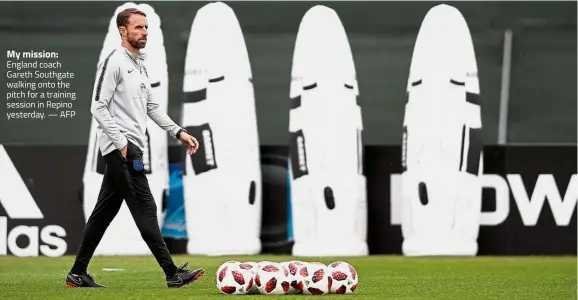  ??  ?? My mission: England coach Gareth Southgate walking onto the pitch for a training session in Repino yesterday. — AFP